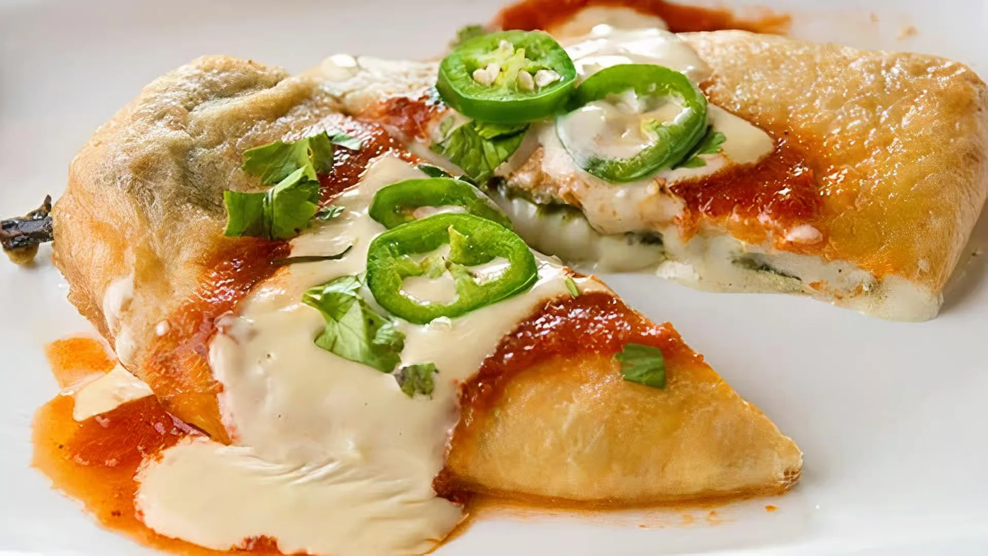 Chile Relleno - A classic roasted poblano pepper stuffed with melted cheese, lightly battered and fried to golden perfection, served with rice and beans.